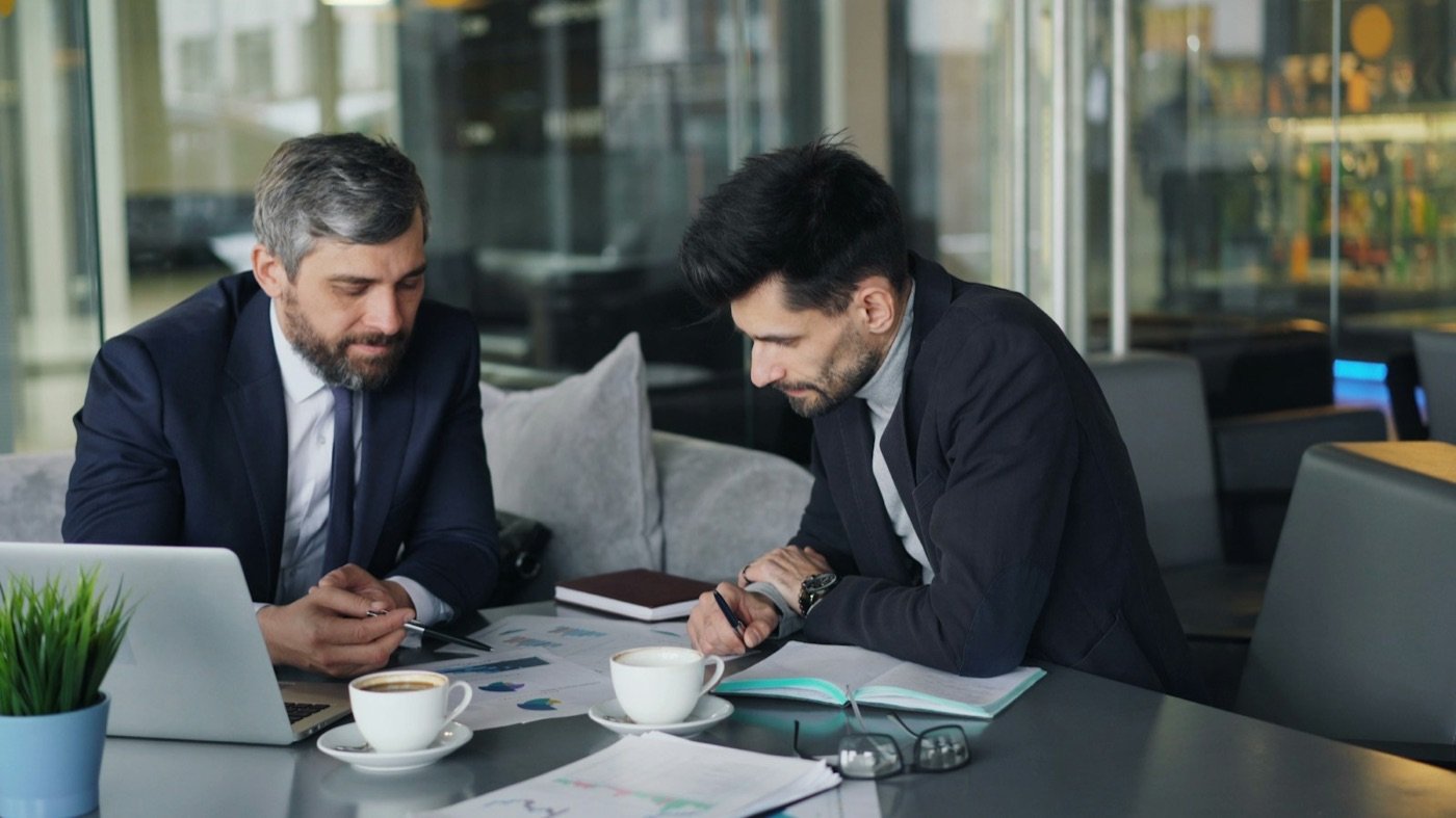 Dos socios revisando resultados sobre la mesa de trabajo